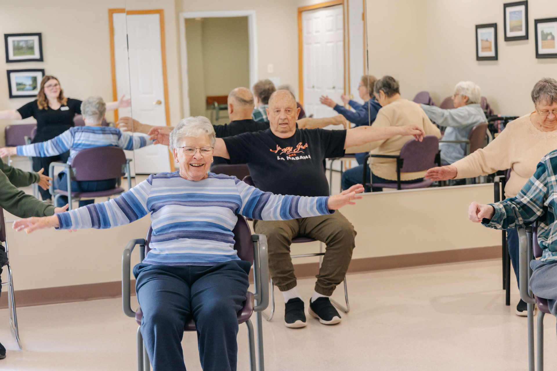 Senior residents participating in a group chair exercise class at Harvest House in Olds, Alberta