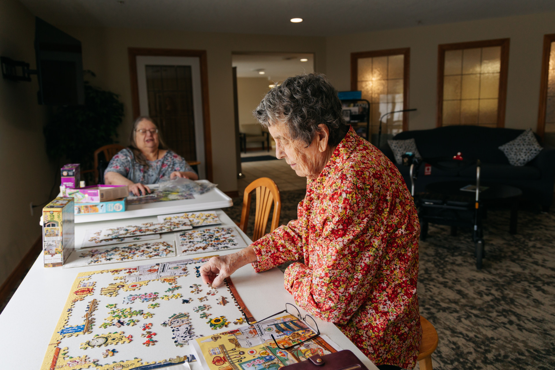 Harvest House caregiver assisting a senior resident at mealtime in Olds, Alberta