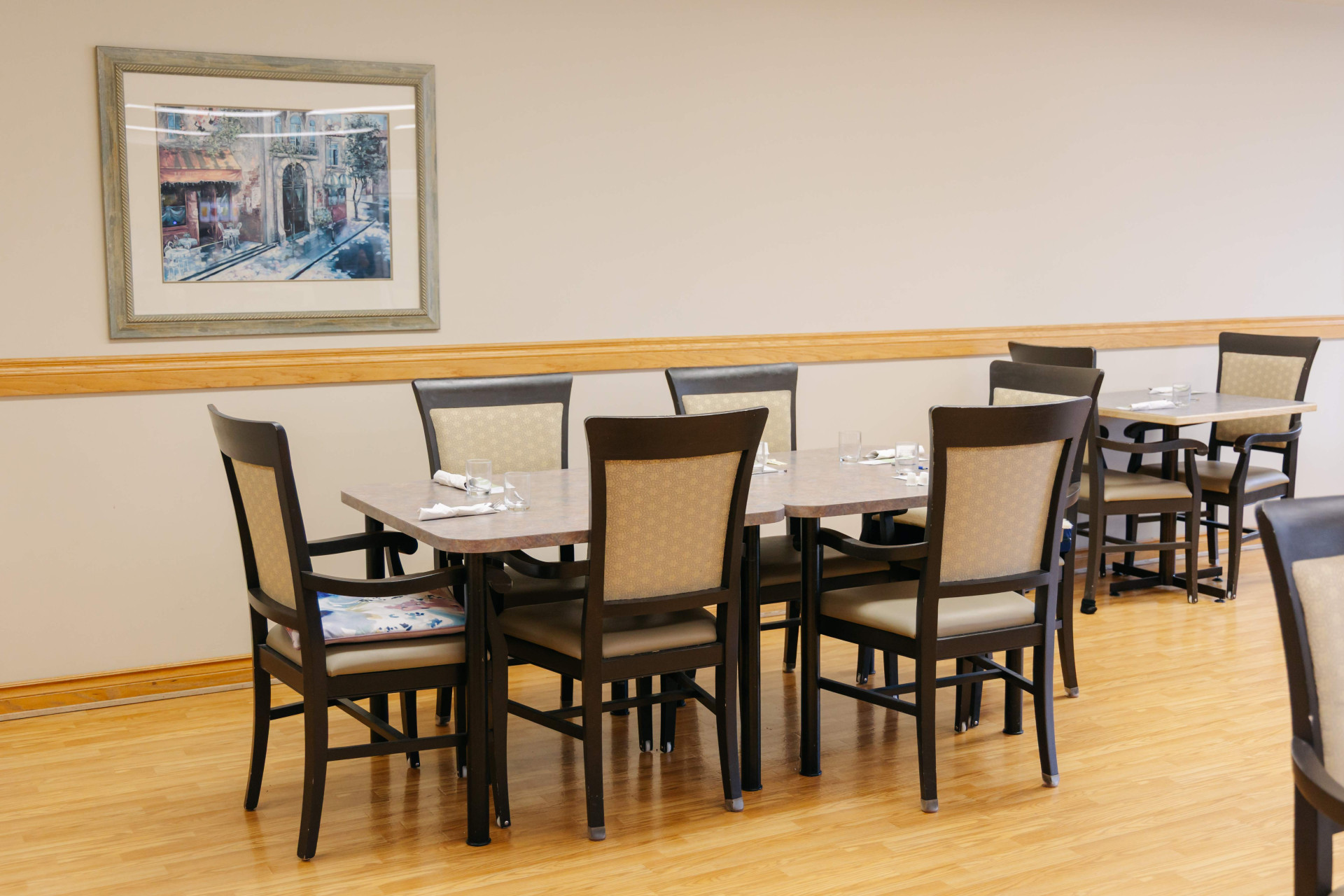 Warm, spacious senior dining room at Harvest House in Olds, Alberta set for mealtime
